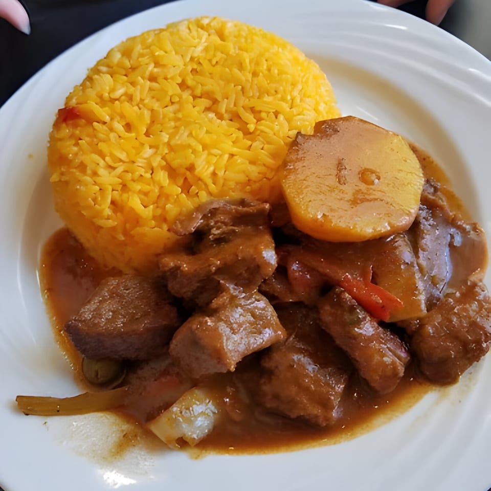 Parrilla Latina's Latin-American dish with yellow rice, beef stew, potatoes, and red peppers.
